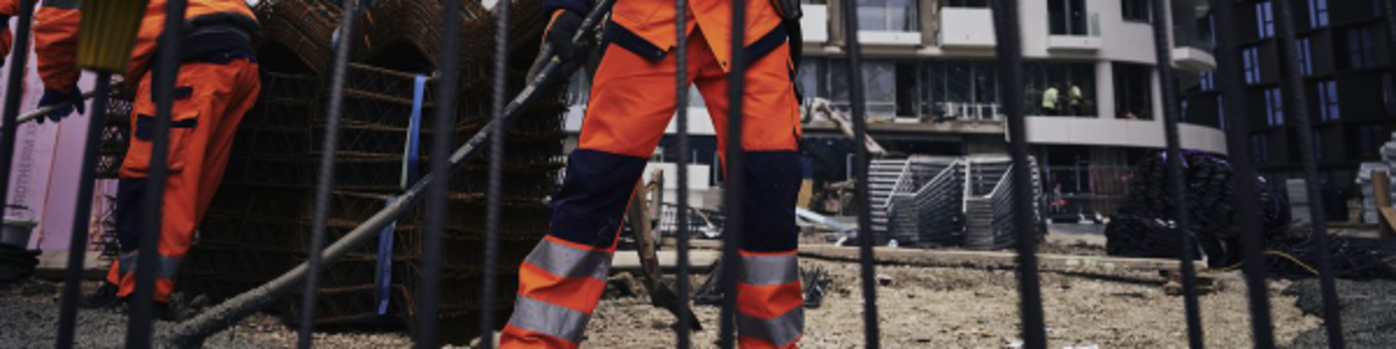 Construction worker on a construction site compacting concrete with a Wacker Neuson internal vibrator.